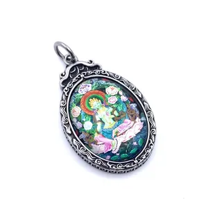 Macro shot of titanium steel Green Tara Thangka pendant with colorful floral relief