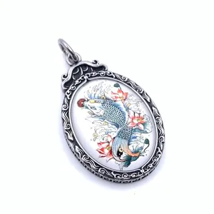 Macro shot of titanium steel pendant with painted koi fish and pink lotus flowers