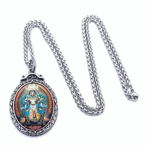 Macro view of colorful Tibetan Thangka pendant with intricate vintage steel frame