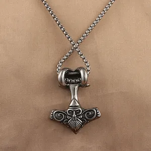 Macro detail of Viking Mjölnir pendant with Odin face carving and thick box chain