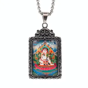 Détail macro du pendentif Thangka montrant une peinture de divinité et des volutes