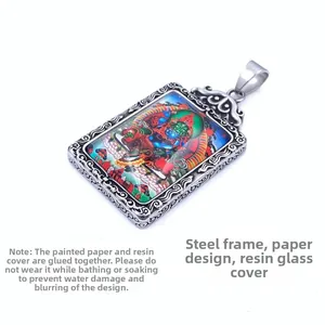 Vue détaillée du pendentif en acier titane avec motif religieux et coque en résine