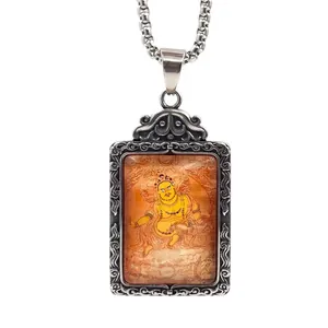 Détail du pendentif Zambala en acier titane avec relief floral et chaîne maille