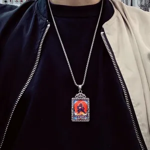 Gros plan d'un pendentif Thangka en acier inoxydable avec gravures florales rétro