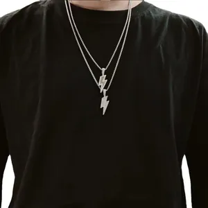 Detalle de collares de acero inoxidable con colgantes de rayos y circonitas micro-pave