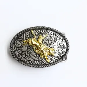 Detail van western riemgesp met zilveren krullen en goudkleurige stierenrijder inlay