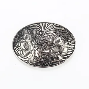 Detailweergave van de vintage ovale zilveren riemgesp met turkoois en bloemenreliëf