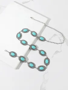 Close-up of bohemian silver waist chain with turquoise stones and engraved floral details