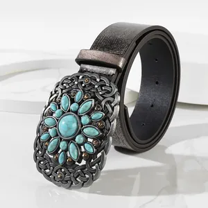 Vintage bohemian wide leather belt with oversized turquoise buckle on marble surface