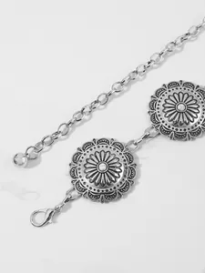 Dettaglio della catena da vita boho in argento con medaglioni incisi e pietre bianche