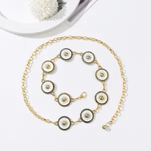 Detail of gold metal waist chain with white enamel sun pendants and lobster clasp