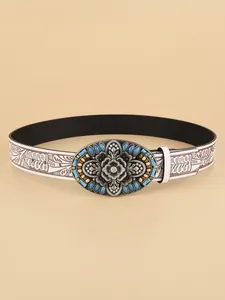 Detail of bohemian white belt featuring vintage floral embossing and turquoise buckle