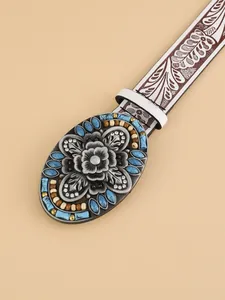 Detailed view of bohemian belt buckle with turquoise inlay and embossed floral patterns