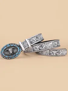 Detail of western belt buckle with longhorn skull, turquoise stones and studded leather strap