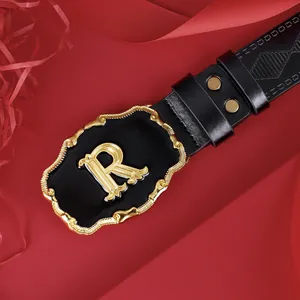 Ceinture homme en cuir avec boucle R en émail noir et détails dorés sur fond de soie rouge