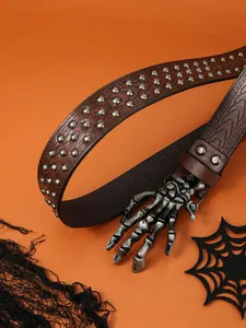 Detail of a brown leather belt featuring silver skull hand buckle and stud accents