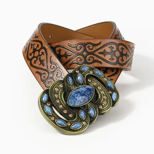 Vintage brown leather belt with embossed patterns and bronze buckle with blue stones