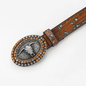 Western leather belt with embossed floral pattern, bull skull buckle and turquoise accents