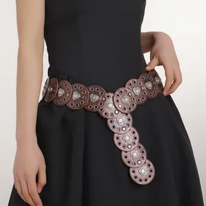 Detail of Western belt featuring brown circular leather pieces and silver heart motifs