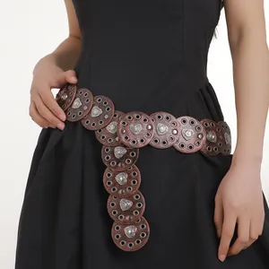 Detail of Western belt with brown circular panels and silver heart-shaped studs on black dress