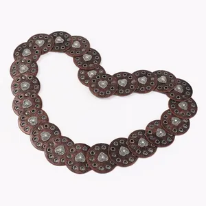 Detail of round leather discs with silver heart studs on a boho western style waist belt
