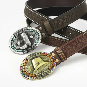 Macro view of vintage western belts with embossed leather and ornate cowboy buckles