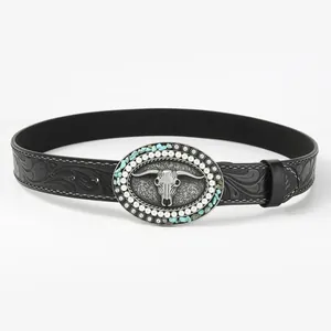 Detail of western belt buckle with silver bull skull and turquoise stones on black strap