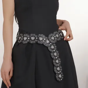 Detail of western cowboy belt featuring silver heart studs and hollow metal eyelets