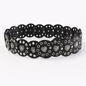 Close-up of black western belt with round leather pieces and heart-shaped metal buckles