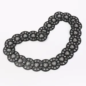 Detail of western belt with black leather circles and silver heart-shaped metal studs