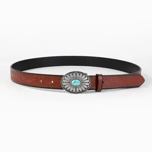 Close-up of vintage brown leather belt with embossed floral patterns and turquoise buckle
