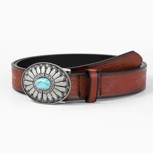 Detail of western embossed leather belt featuring a silver buckle with turquoise stone