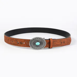 Detail of bohemian leather belt with floral embossing and turquoise buckle inlay