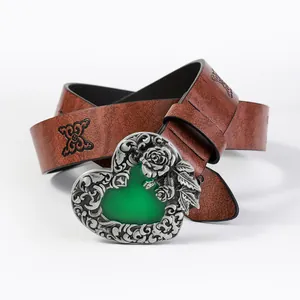 Detail of vintage heart-shaped metal buckle with green stone and floral rose patterns