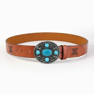 Detailed view of vintage brown leather belt with embossed patterns and turquoise buckle