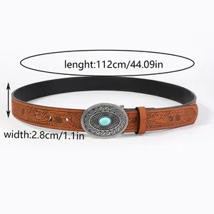 Detail of bohemian brown belt with embossed floral patterns and turquoise metal buckle