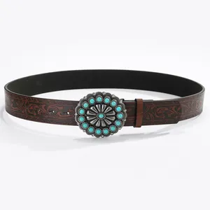 Detail of western cowboy belt with embossed leather and turquoise studded metal buckle