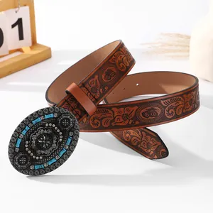 Detail of vintage brown leather belt with floral embossing and turquoise metal buckle