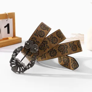 Detailed view of bohemian leather belt with floral prints and rhinestone butterfly buckle