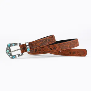 Detail of bohemian embossed leather belt featuring turquoise studded vintage silver buckle