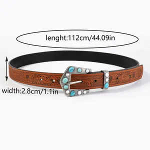 Detail of bohemian leather belt featuring floral embossing and turquoise buckle inlay