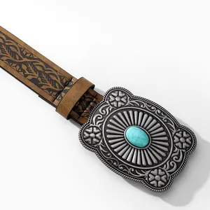 Detail of vintage western belt showing floral embossed leather and turquoise buckle