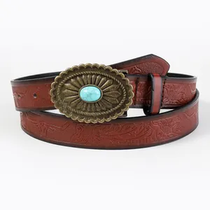 Close-up of vintage embossed leather belt with turquoise stone buckle in western style