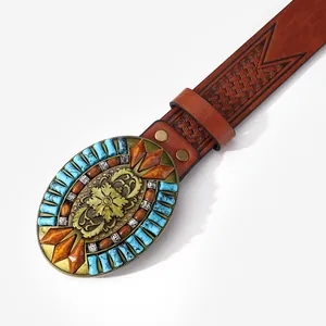Close-up of vintage cowboy belt buckle with turquoise beads and floral relief