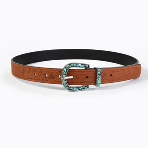 Close-up of bohemian leather belt featuring floral embossing and a bull head buckle