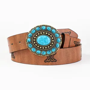 Macro detail of bohemian oval buckle with blue turquoise stones and floral leather belt