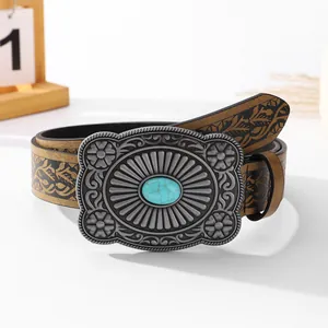 Close-up of vintage belt buckle with turquoise inlay and embossed floral patterns