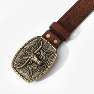Macro detail of western belt featuring a vintage bronze bull head buckle and embossed leather
