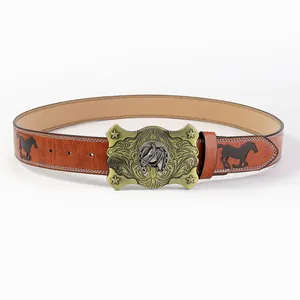 Dettaglio della fibbia western in bronzo con motivi di cavalli e cintura in pelle goffrata