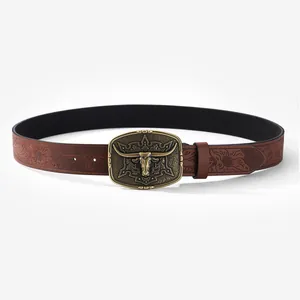 Detail of vintage brown leather belt with embossed floral patterns and bull head buckle